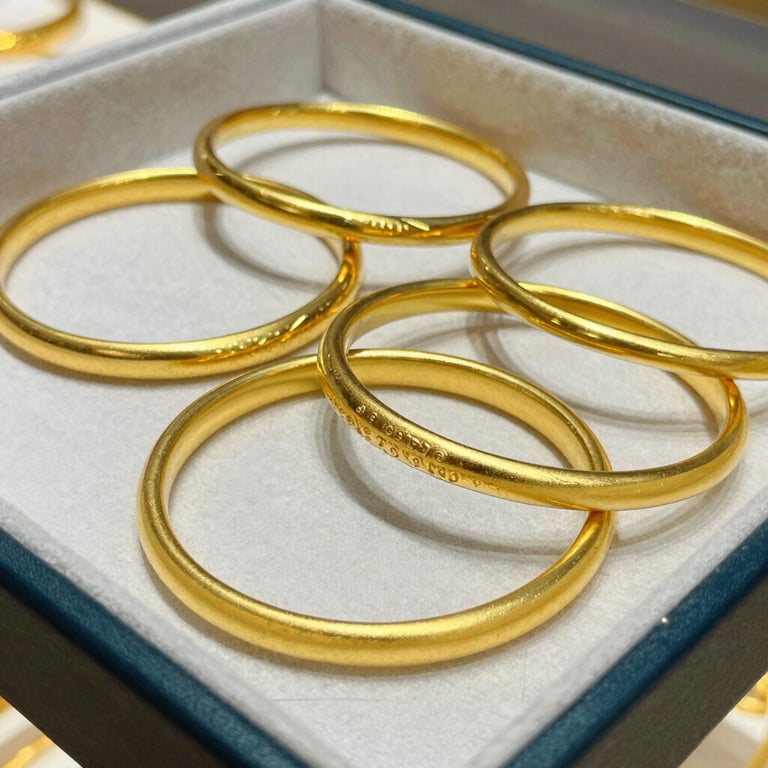 Close-up of polished gold bangles stacked neatly in a premium wholesale display tray.