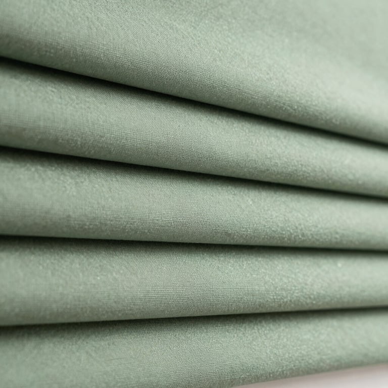 Close-up of elegant, custom-fit roller blinds in a soft sage green fabric.
