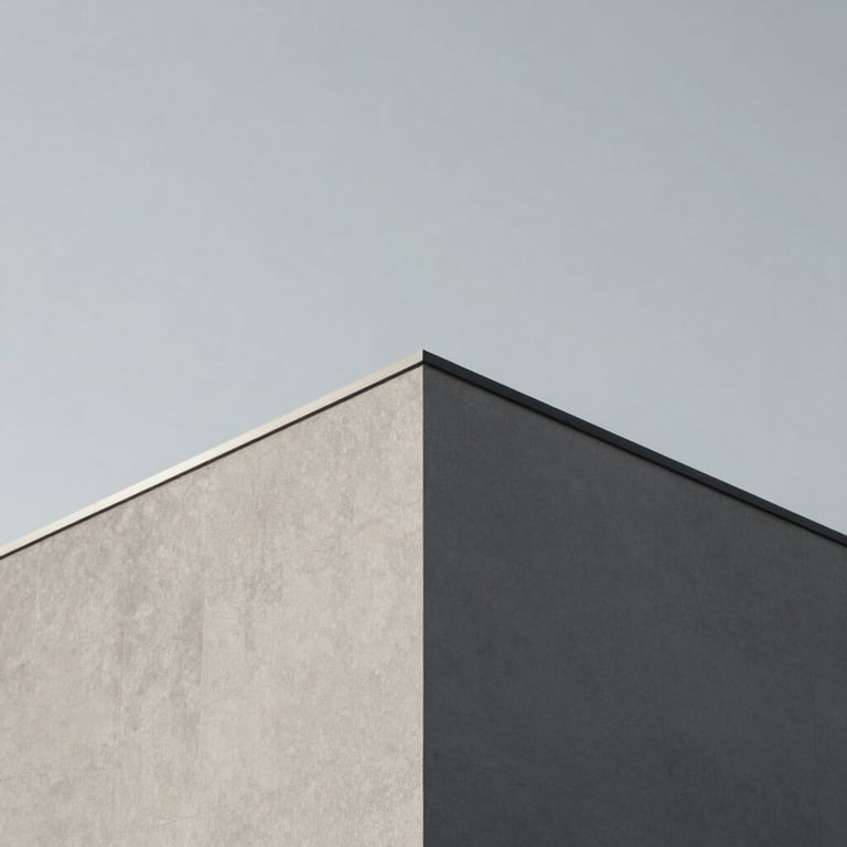 Minimalist shot of a sharp building corner against a clear light grey sky, focusing on the intersection of planes.