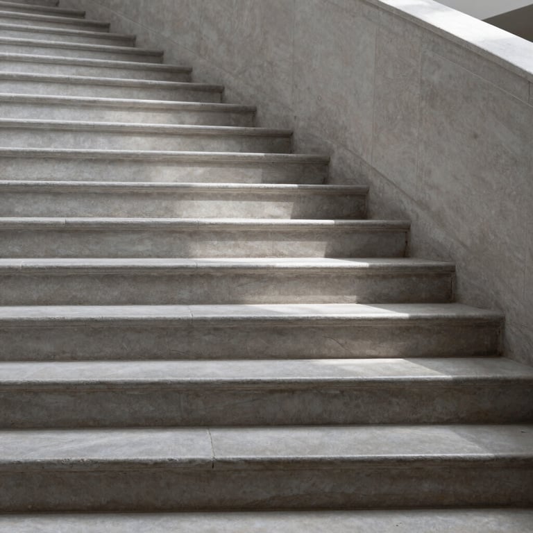 Architectural detail of an interior staircase made of light grey stone, showing precise shadows and geometric repetition.