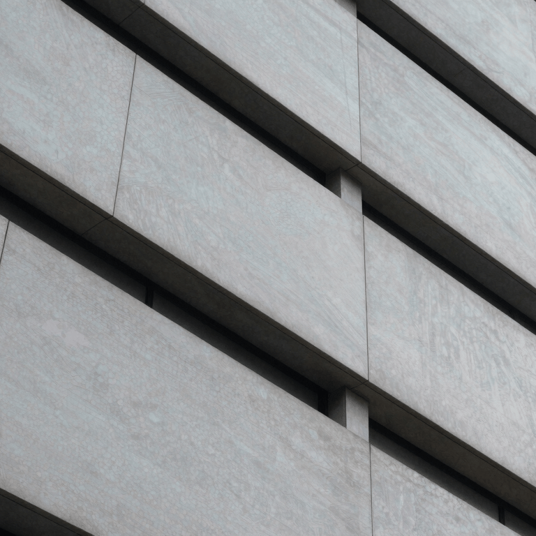 A young professional in a modern British / UK office wearing a deep crimson red blazer, working at a minimalist soft pale grey desk.