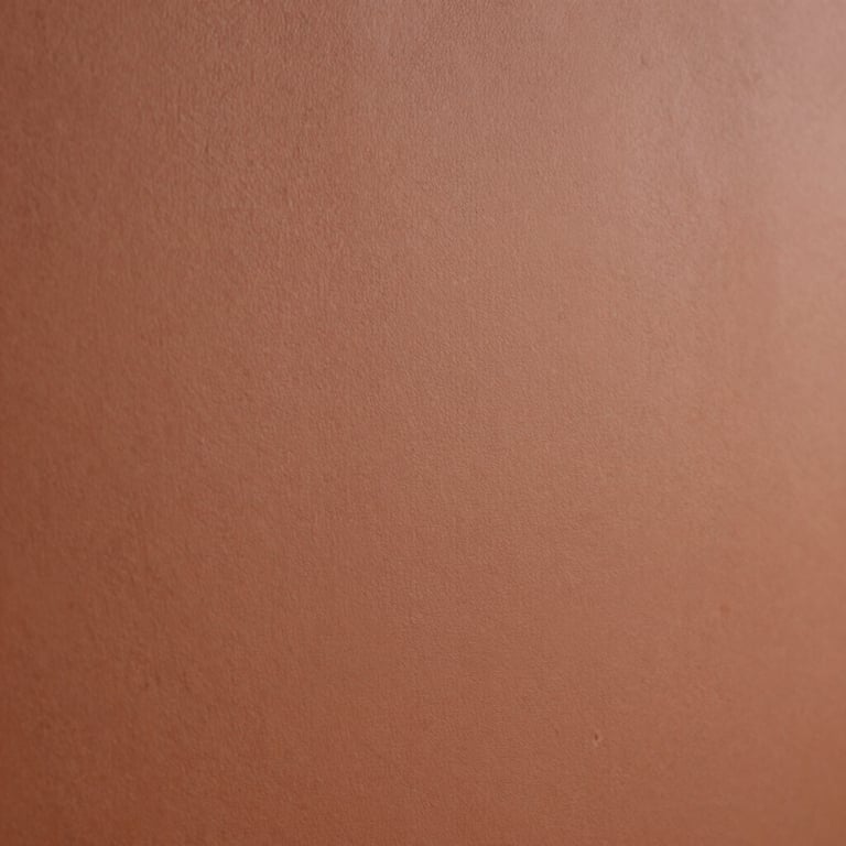 Close-up of a perfectly smooth terracotta finish on a textured bedroom wall, professional quality.