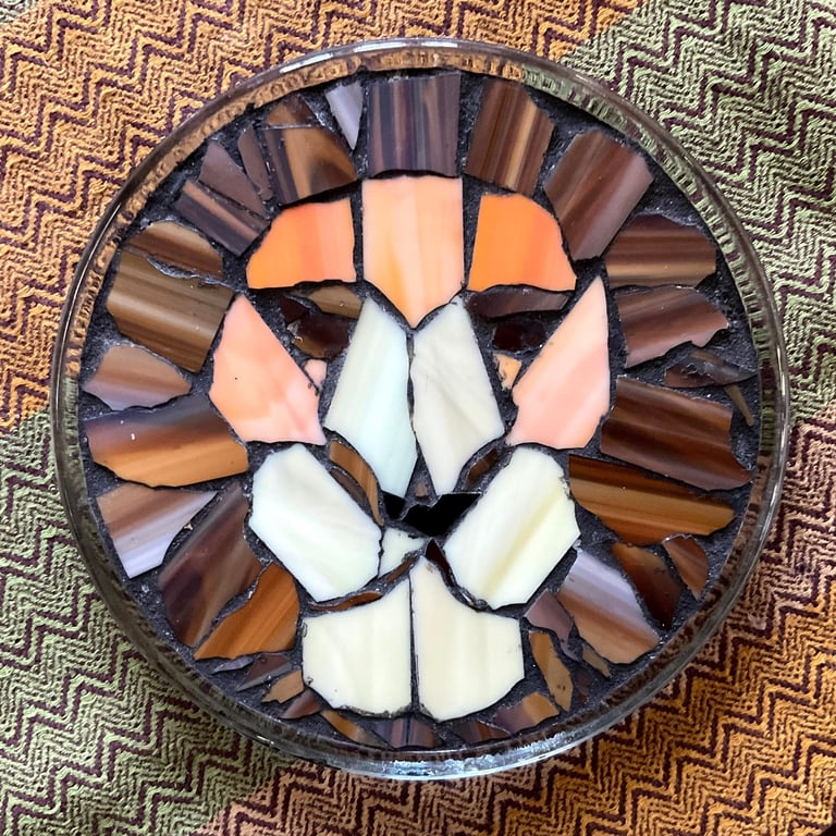 Intricate glass mosaic of a lion's face, titled "Dad's Leo," with warm & earth toned fragments.