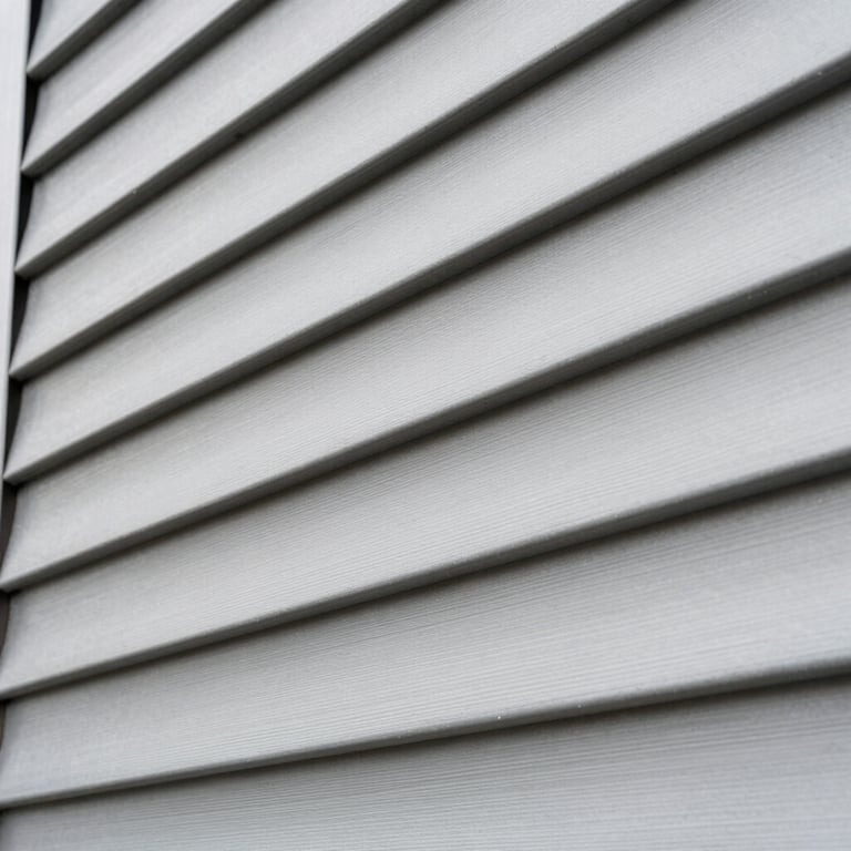 A detailed shot of modern zinc siding on a residential facade, showing the overlapping panels and professional installation.