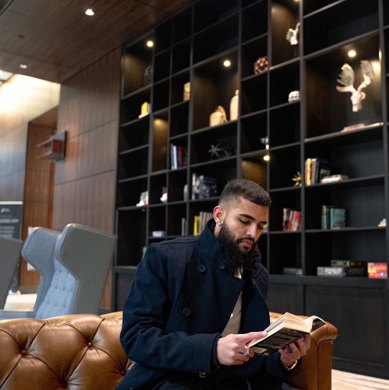 a man sitting on a couch reading a book Mohit Dhillon