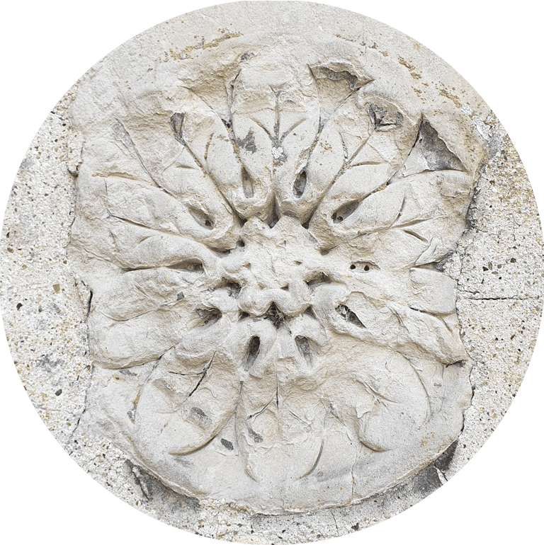 A 12-fold rosette of leaves in masonry, set roughly in mortar.