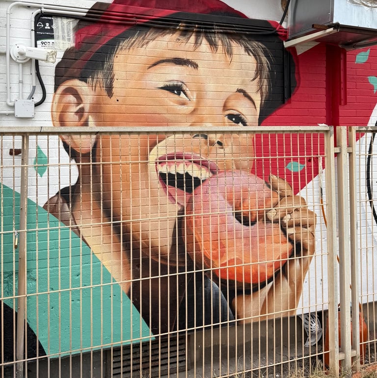 Mural de gran formato sobre fachada urbana realizado con aerosol. Representación figurativa que comb