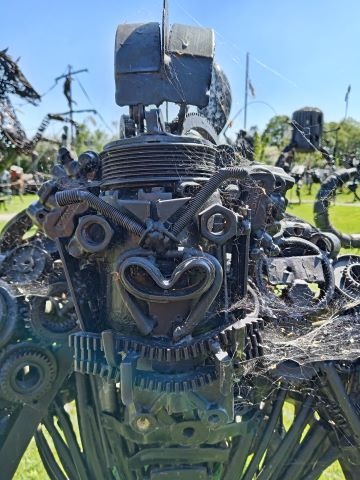 A detailed scrap metal gorilla sculpture made from recycled gears, bolts, and industrial parts.