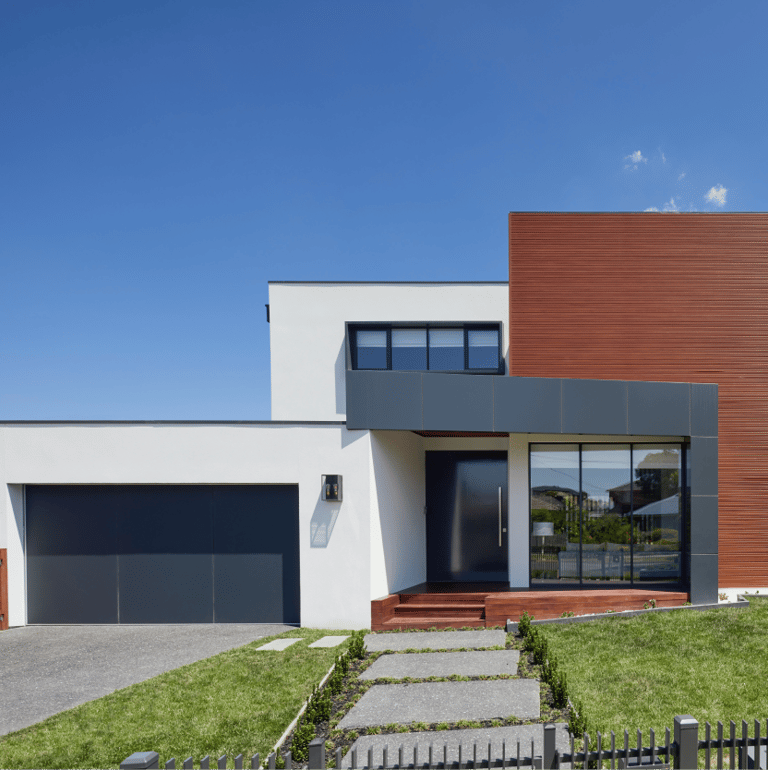 Una casa de construcción en seco con entrada para autos y área cercada.