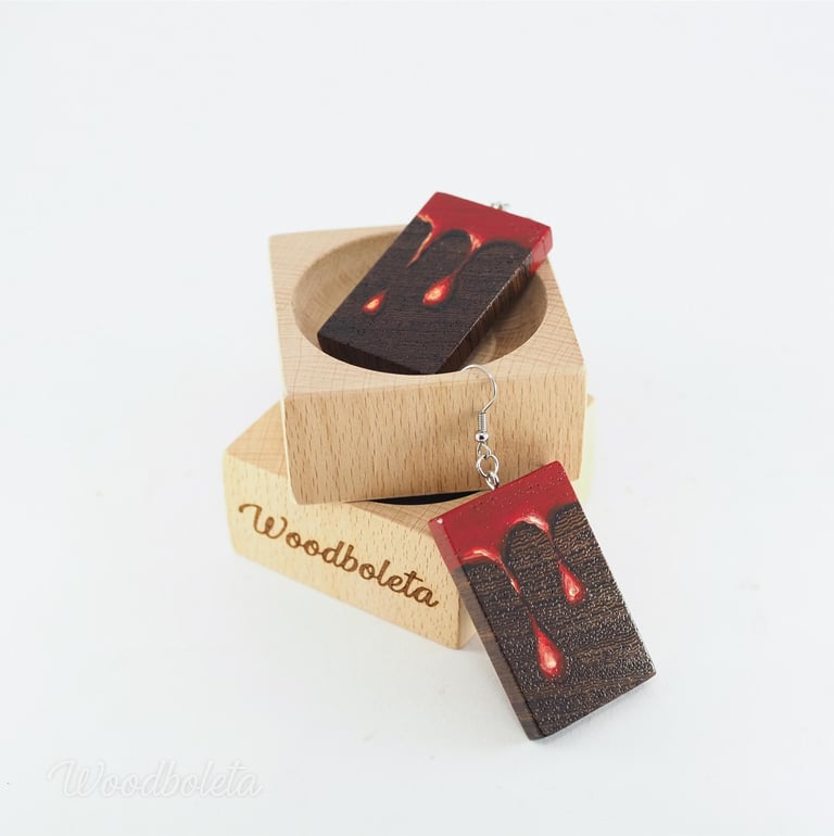 wooden earrings hand painted with paint dripping motif, displayed on wooden cube display
