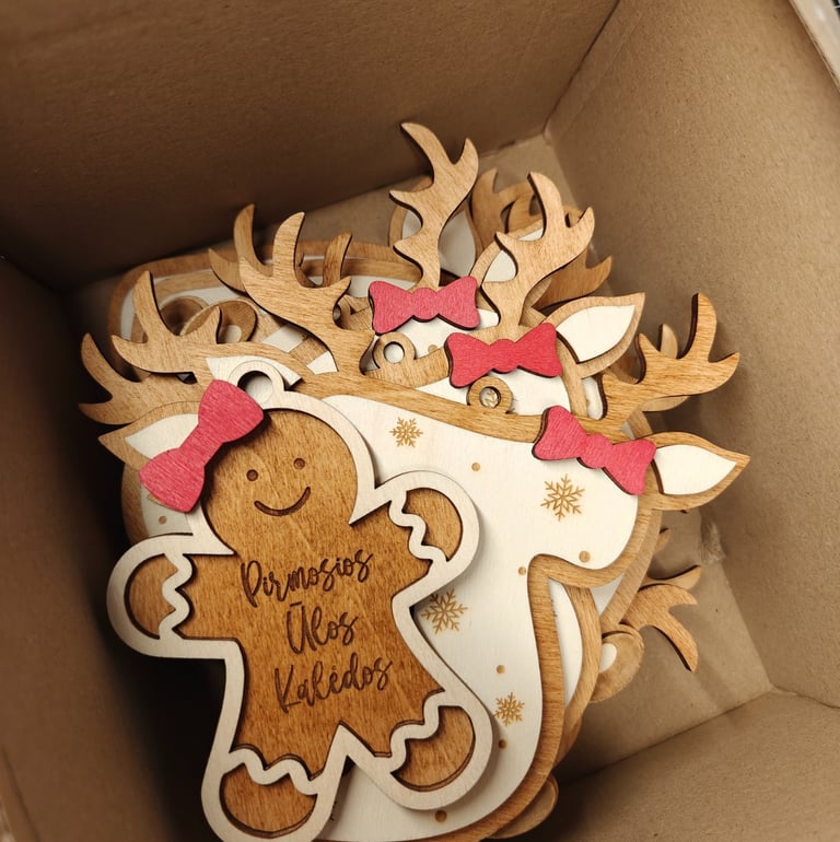 Graviruoti spalvoti kalediniai zaisliukai su raudonais kaspinais ir graviruotais vardais