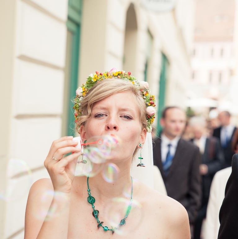 a bride and groom blowing bubbles in the air