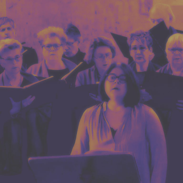 A community choir group performing a vocal concert with sheet music under purple and gold lighting.
