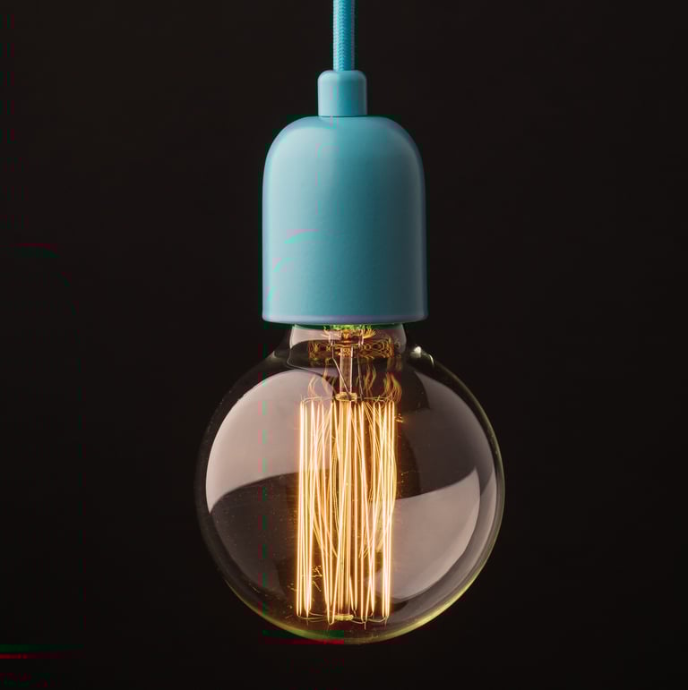 Product photography - a light bulb hanging on a black background