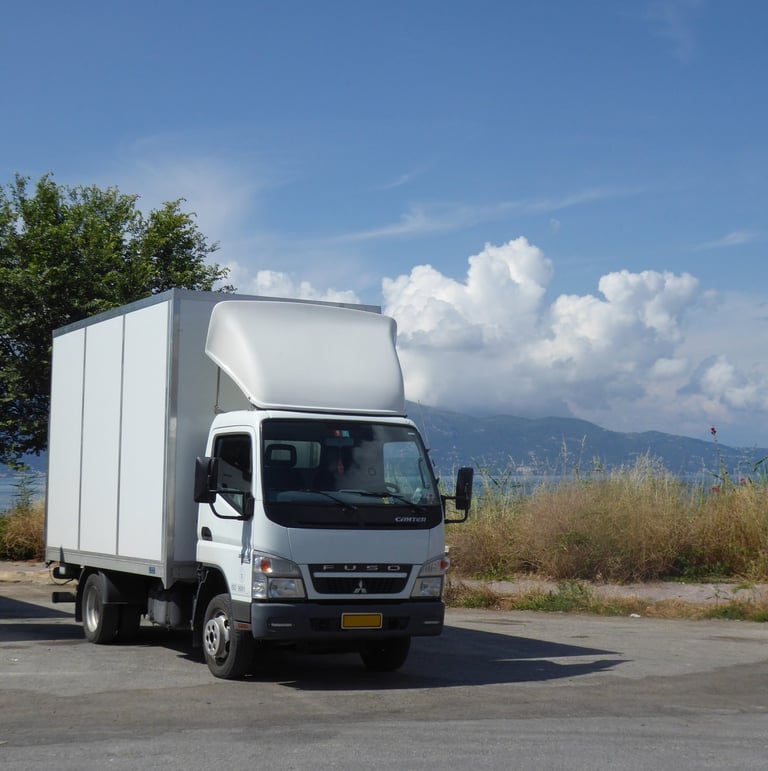 A white Luton type van is shown with a backdrop of the sea