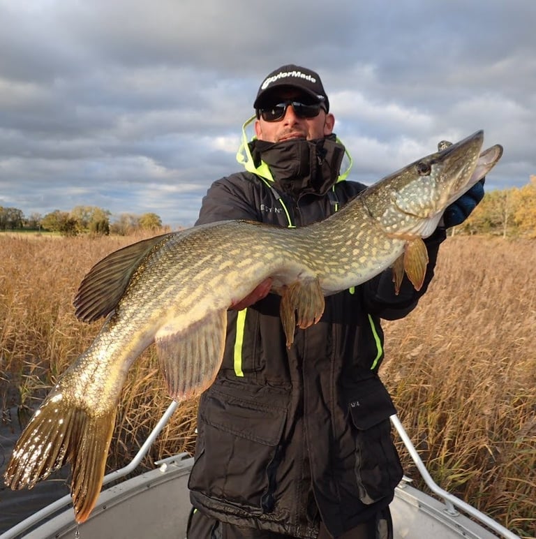 un pêcheur porte un brochet