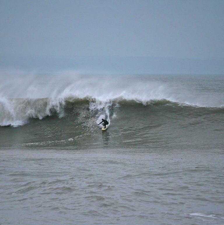 A surfer rides a big wave during winter