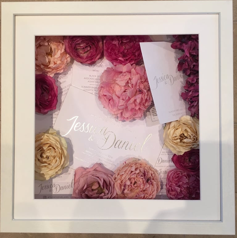 memory box full of wedding invitations and preserved wedding bouquet flowers in a deep frame