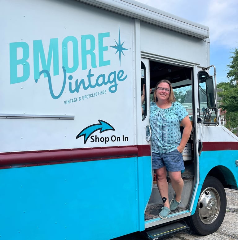 Shop owner standing in the door of a blue and white truck