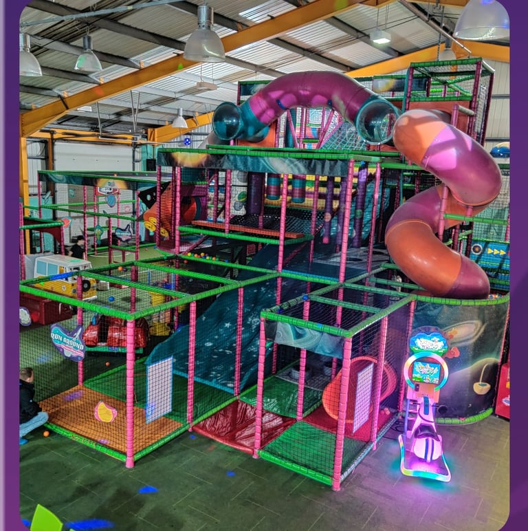 a play area with a soft play frame and 2 slides