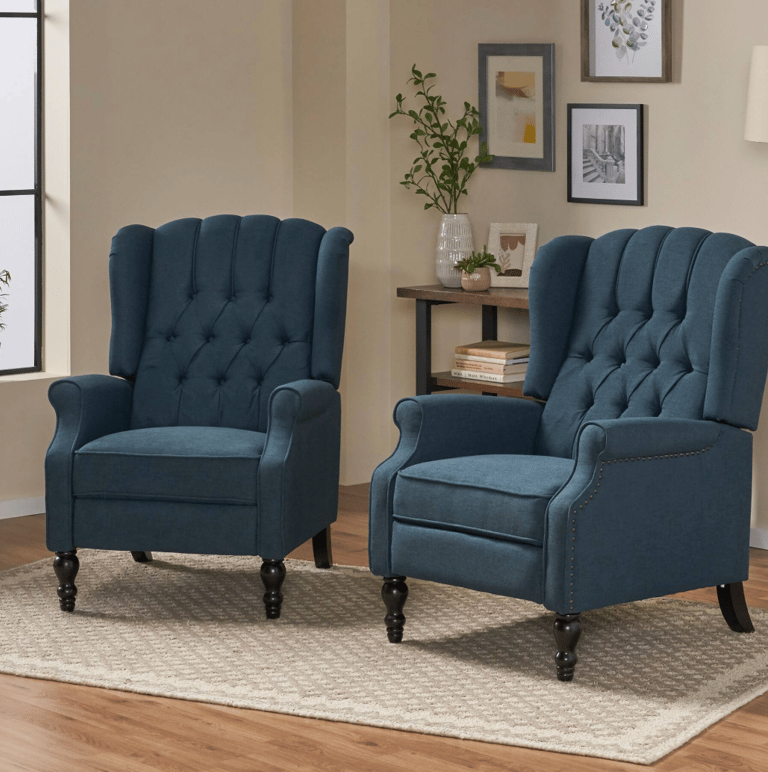 Two navy blue tufted wingback recliners on a neutral rug in a cozy living room.