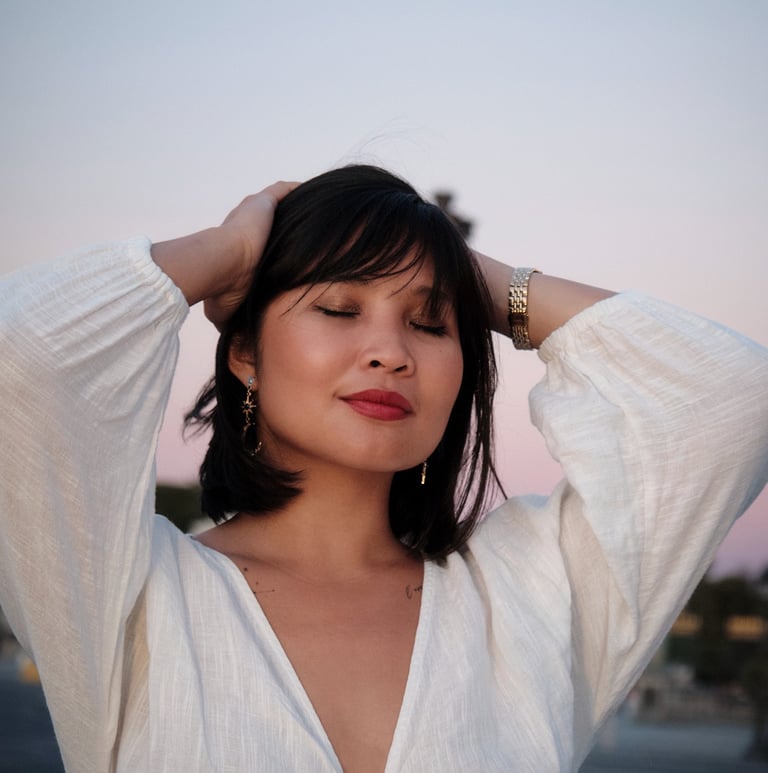 Modèle femme brune avec une chemise blanche sur un fond de ciel le soir