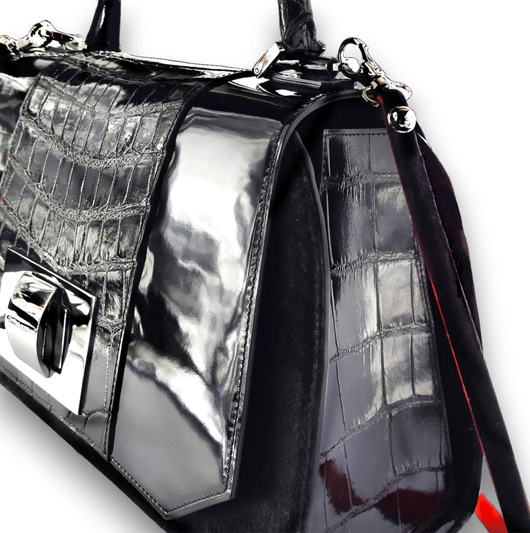 Luxury black crocodile skin handbag with shiny silver hardware and patent leather details.