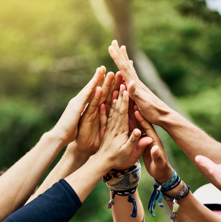 Group of people put their hands together in celebration