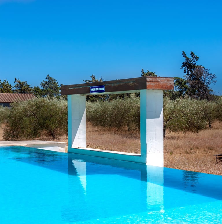 Swimming pool with beach chairs, wide view and waterfall cascade built-in at Domaine Des Lucques