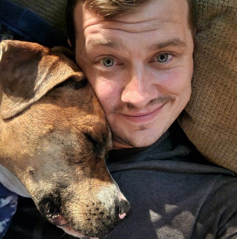 a man is laying down on a couch with his dog