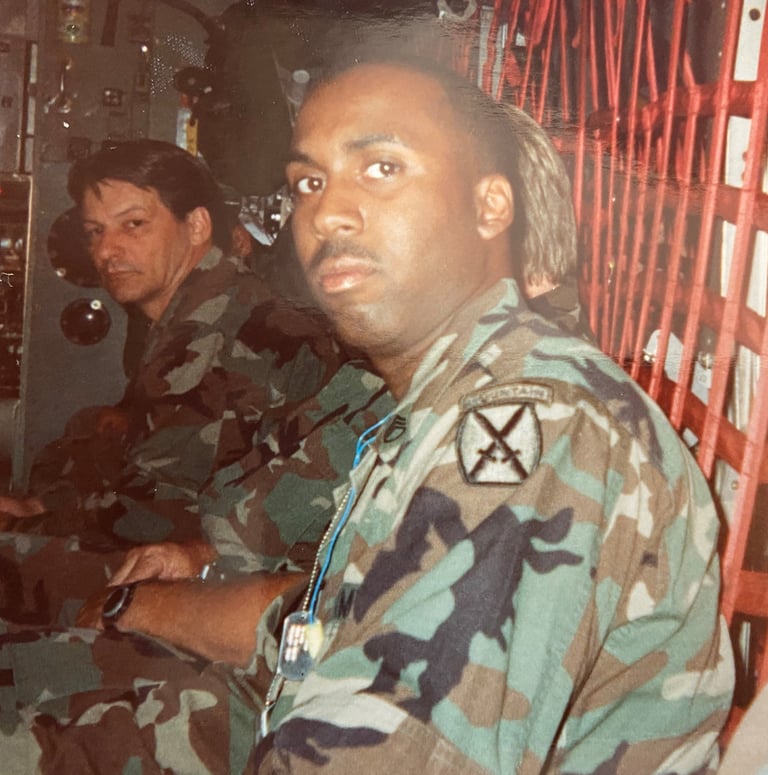 Lee A Jones in camouflage gear sitting in a military transport helicopter