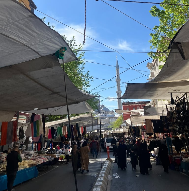a street market scene with a lot of people walking around