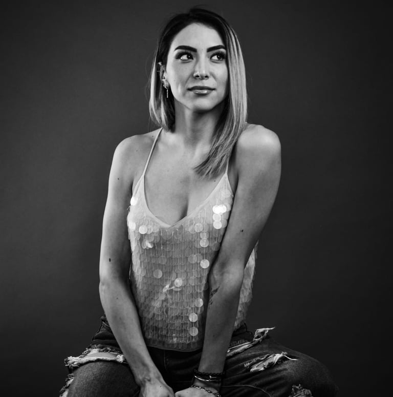 Retrato en blanco y negro de una mujer que lleva una blusa de lentejuelas y vaqueros desgastados.