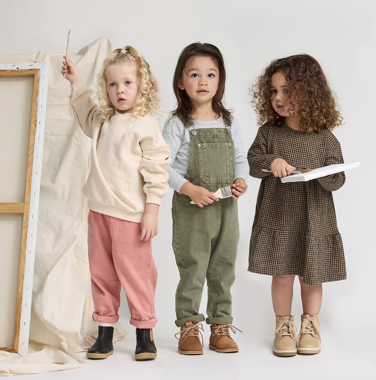 Fashion campaign photography - three young children standing in front of a white canvas