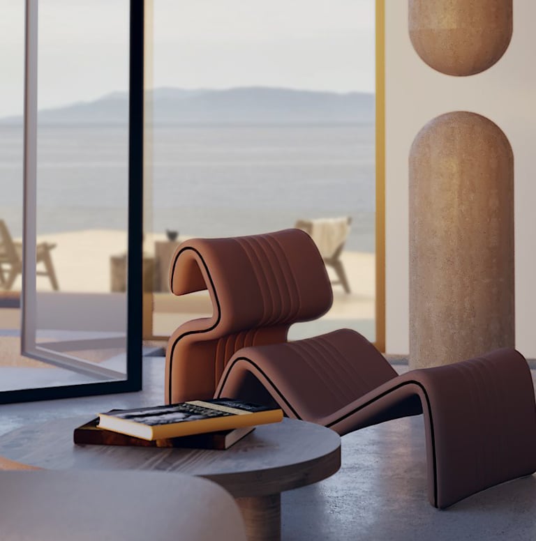 Close-up of a sculptural lounge chair beside a round wooden table in a serene, ocean-facing interior