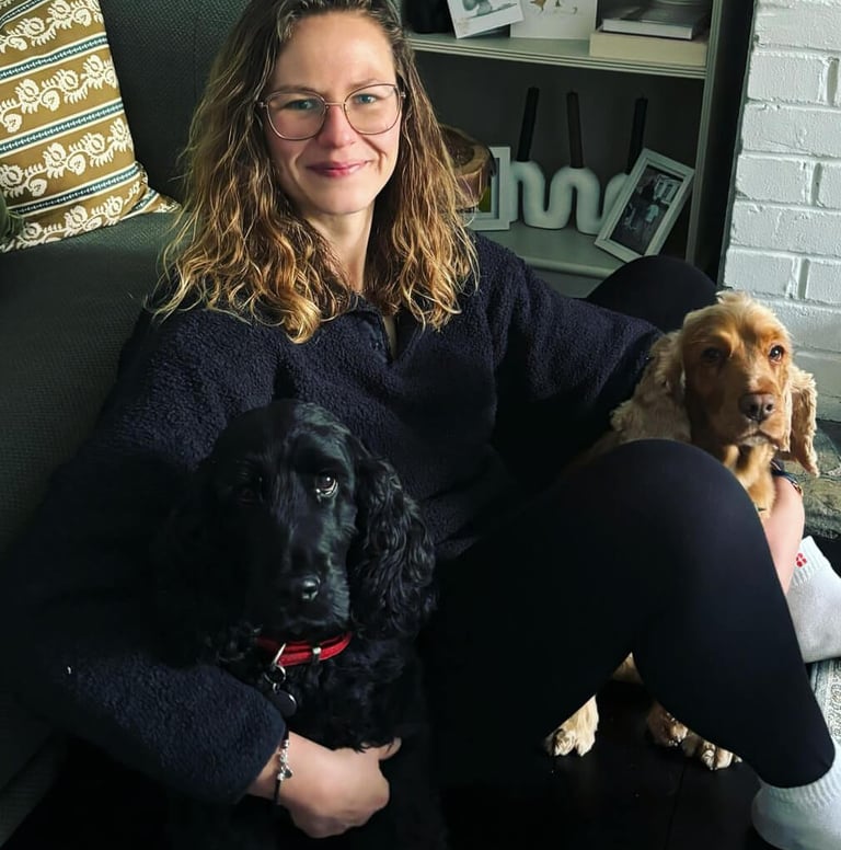 a woman sitting on a couch with two dogs