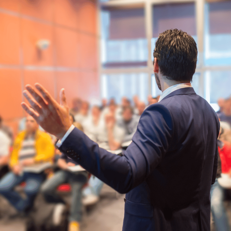 a man in a suit and tie is giving a presentation