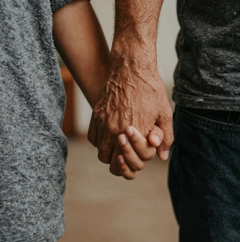 A close-up artistic shot of a parent's hand holding a child's hand in a South American / Brazilian home setting. Warm light grey and dark charcoal tones in the clothing. Soft focus background, intimate and emotional atmosphere.