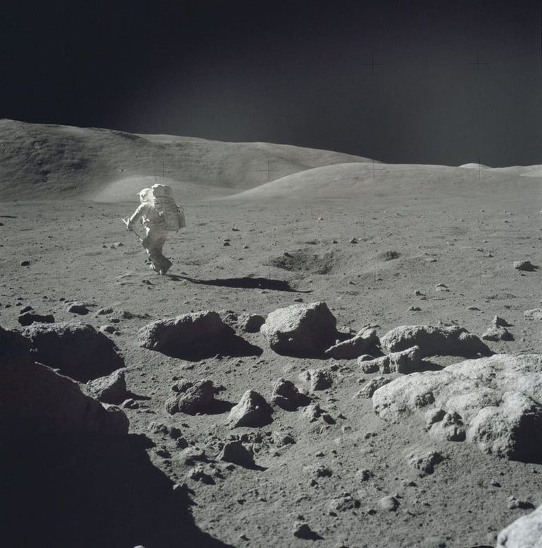 An astronaut in a white space suit walks across the rocky, cratered lunar surface during a moon mission.