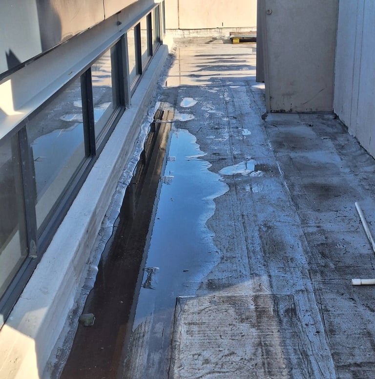 Standing water on flat roof due to poor drainage