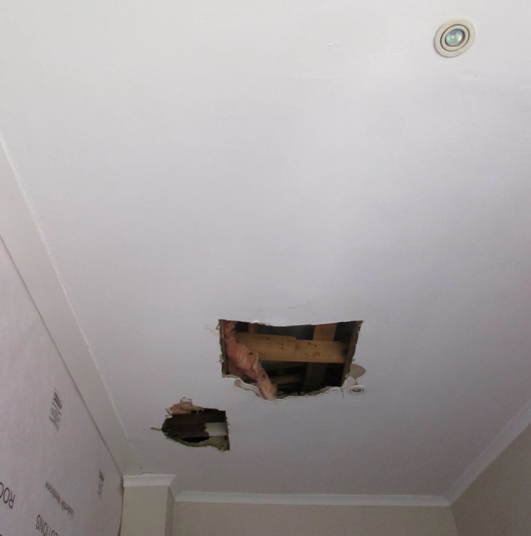 Hole in ceiling showing roof board failure