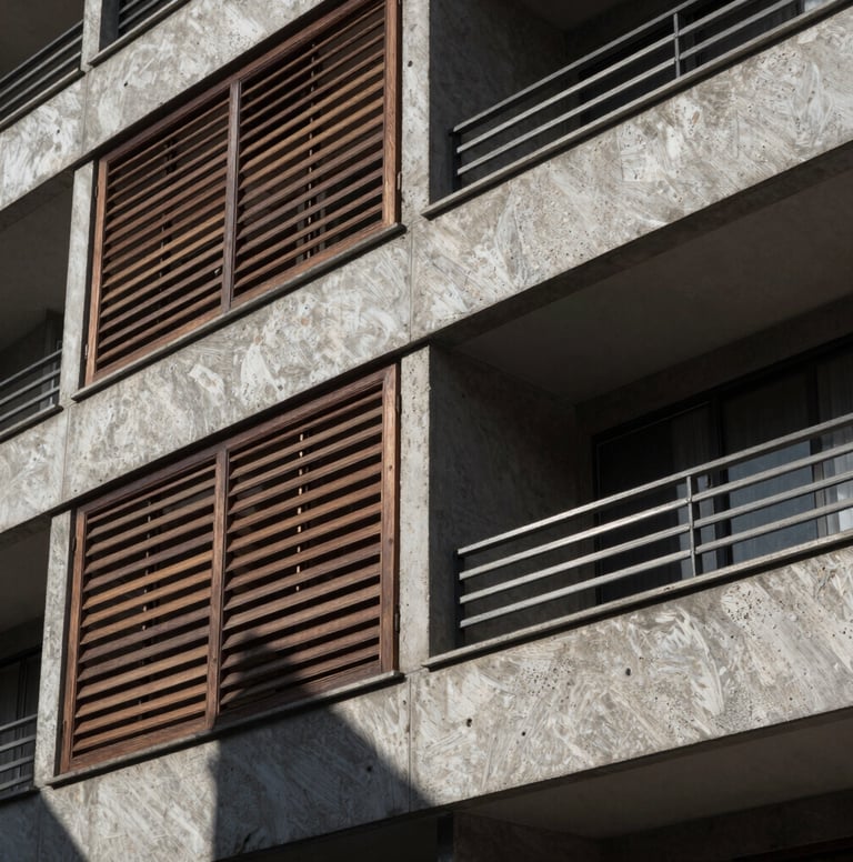 A close-up, high-contrast architectural detail shot of a modern residential facade in a South American / Brazilian urban environment. Focus on the interplay between dark wood louvers and raw gray concrete. Sharp, direct sunlight creating a rhythmic shadow pattern.