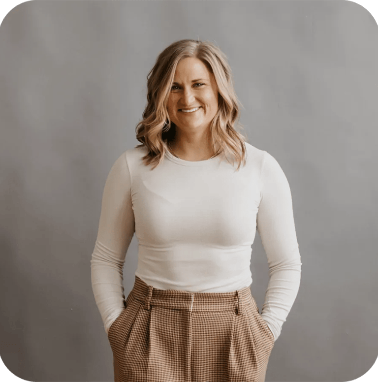 A professional portrait of a woman named Callan Faulkner, smiling while wearing a white long-sleeved