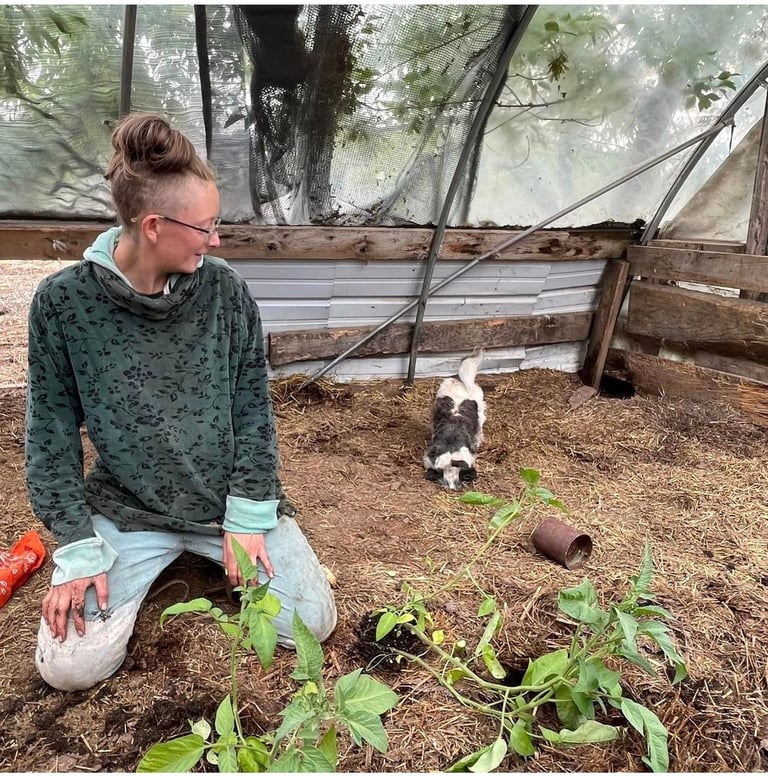photo of Kia Beth with Cricket the dog in the greenhouse