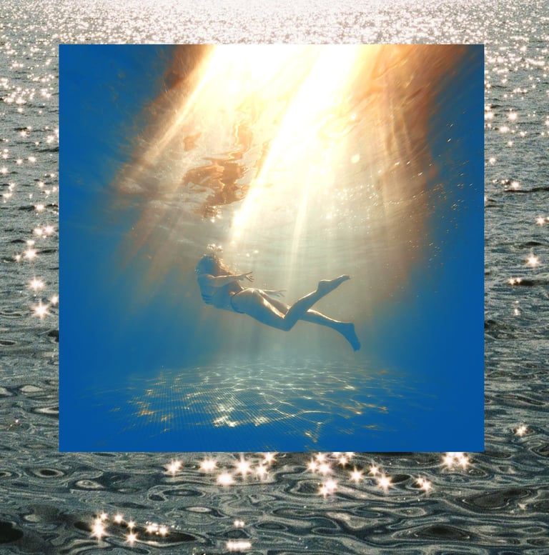 person swimming in deep water with beautiful light shining from above and sparkling ocean waves