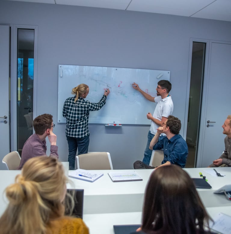 Medical device engineers collaborating at a whiteboard, demonstrating technical expertise