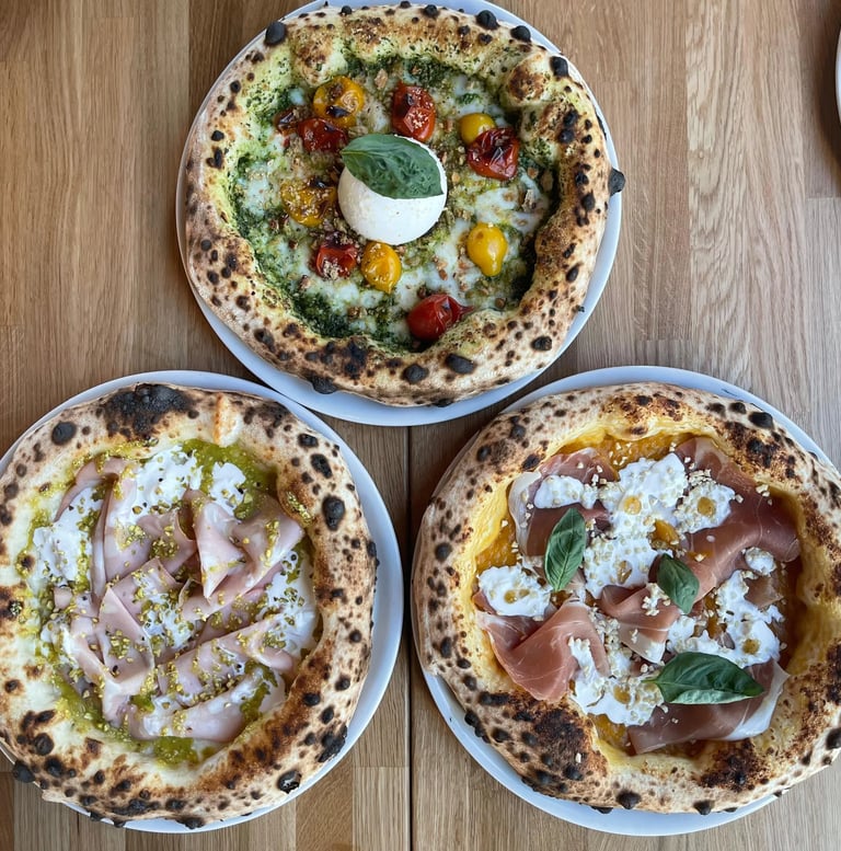 Trois pizzas napolitaines artisanales servies au restaurant Histoire sans Faim à Lausanne : burrata et tomate