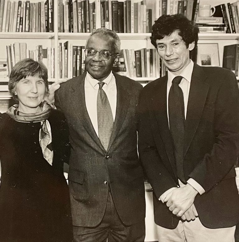 a woman and two men standing in front of a bookcase