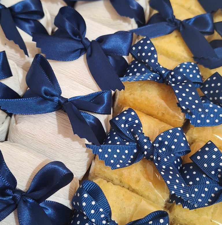 Wrapped party favors and gourmet cakes decorated with elegant navy blue satin and polka dot bows.