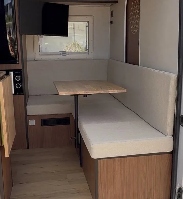 Una furgoneta con un sofá y una mesa en la parte trasera.